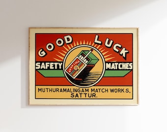 May include: Vintage style matchbox label with a red background and a yellow sunburst. The text reads "Good Luck Safety Matches" and "Muthuramalingam Match Works, Sattur".