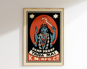 Puede incluir: Una etiqueta de caja de cerillas vintage con una ilustración colorida de una diosa hindú con múltiples caras y una lengua roja. El texto en la etiqueta dice "Damp Proof Tara Mai K.M. Mfg. Co."