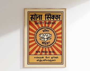 May include: Vintage style matchbox label with a red, yellow, and orange color scheme. The label features a lotus flower graphic and the text "सोना सिक्का" in Hindi, which translates to "Gold Coin". The text "SAFETY MATCHES" is also included, along with the price "50's PRICE 20 Ps".