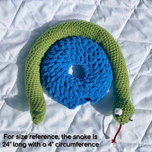 May include: A green crocheted snake toy with a blue crocheted ring. The snake is 24 inches long with a 4 inch circumference.