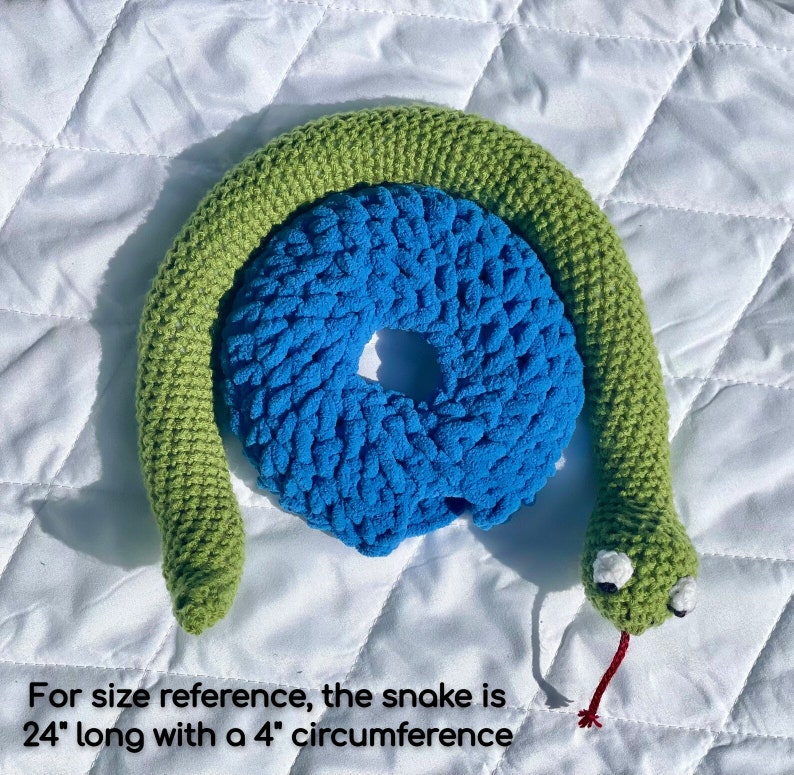 May include: A green crocheted snake toy with a blue crocheted ring. The snake is 24 inches long with a 4 inch circumference.