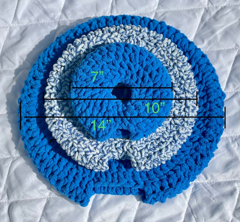 May include: A blue and white crocheted ring with three layers. The inner ring measures 7 inches in diameter, the middle ring measures 10 inches in diameter, and the outer ring measures 14 inches in diameter.