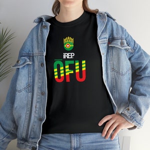 Könnte beinhalten: Schwarzes T-Shirt mit einem grünen, gelben und roten Grafikdesign. Die Grafik zeigt eine Krone, einen Kreis mit einem Vogel darin und den Text "iREP: OFU".