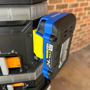 May include: A black and blue 24V MAX Lithium Ion battery pack attached to a black tool. The battery pack has a yellow accent and the brand name "KOBALT" is visible. The battery pack is 2.0 Ah.