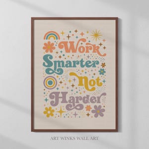 Op de afbeelding: Een ingelijste kunstdruk met de woorden "Work Smarter Not Harder" in een retro lettertype. Het kunstwerk toont een regenboog, bloemen en sterren in tinten oranje, blauwgroen, geel en paars. De tekst "ART WINKS WALL ART" staat onderaan.
