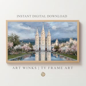 May include: A framed digital print of a white building with multiple spires, reflected in a body of water. The artwork features a light blue sky and surrounding trees with pink blossoms. Text at the top reads "INSTANT DIGITAL DOWNLOAD" and at the bottom "ART WINKS | TV FRAME ART".