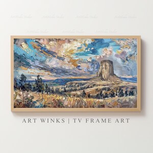 May include: Impasto oil painting of a landscape featuring a prominent rock formation beneath a dramatic sky. The artwork uses a palette of blues, yellows, and browns. The painting is framed in a light wood frame. Text at the bottom reads: ART WINKS | TV FRAME ART.