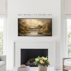 May include: A framed landscape painting of a lake with mountains in the background. The painting is in a brown frame and is hanging on a white wall above a fireplace.
