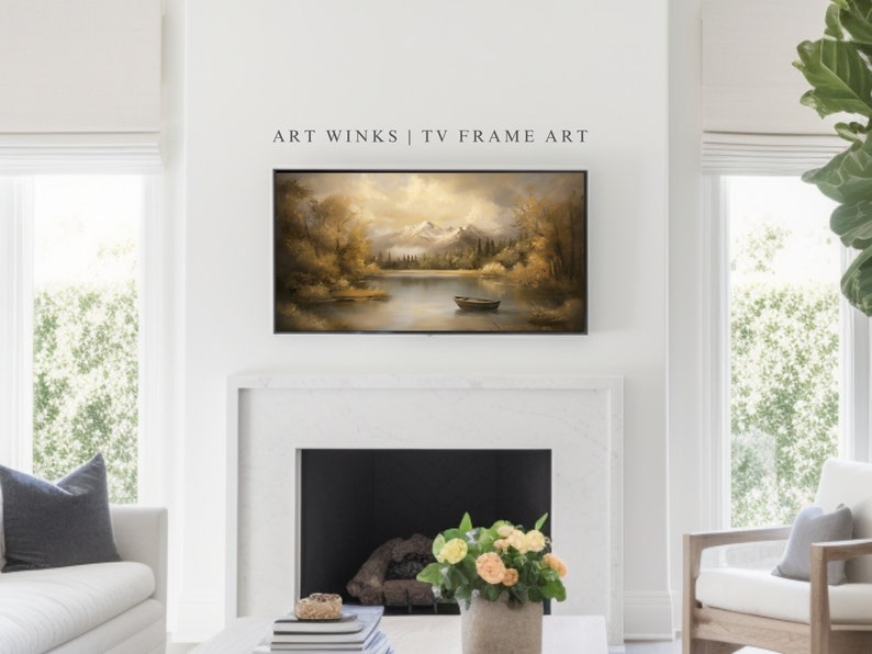 May include: A framed landscape painting of a lake with mountains in the background. The painting is in a brown frame and is hanging on a white wall above a fireplace.