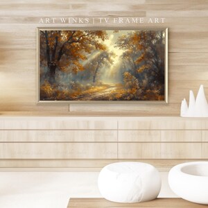 May include: A framed landscape painting depicting a forest scene with a path leading into the distance. The artwork features warm tones of gold, brown, and orange, with sunlight streaming through the trees. The text "ART WINKS | TV FRAME ART" is visible.