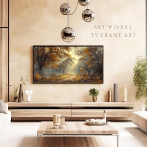May include: A living room with a large TV displaying a forest scene with golden and brown hues. The TV is mounted above a light wood cabinet. The text "ART WINKS | TV FRAME ART" is visible. A modern, minimalist design.