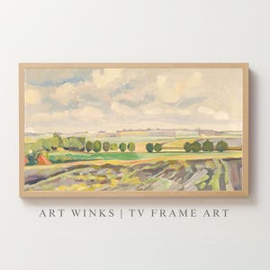Puede incluir: Una pintura de paisaje enmarcada con un marco de madera clara. La obra de arte representa una escena rural con campos, árboles y un cielo nublado. La paleta de colores incluye verdes, amarillos y azules. El texto "ART WINKS | TV FRAME ART" está en la parte inferior.