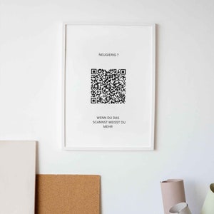 Könnte beinhalten: Ein weißer gerahmter Poster mit einem schwarz-weißen QR-Code und dem Text "Neugierig?" und "Wenn du das scannst weisst du mehr".