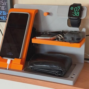 Op de afbeelding: Een set van drie keramische mokken met een gespikkelde, matte afwerking. De mokken zijn in de kleuren crème, lichtgrijs en donkergrijs. Elke mok heeft een eenvoudig, modern ontwerp en een afgeronde handgreep. De mokken zijn op elkaar gestapeld.