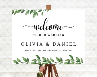 May include: A white welcome sign with green foliage border, featuring the text "welcome to our wedding Olivia & Daniel August 17, 2025 | 123, Anywhere St, Any City".