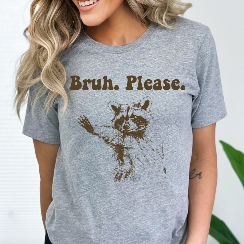 May include: Grey t-shirt with a brown raccoon graphic and the text "Bruh. Please."