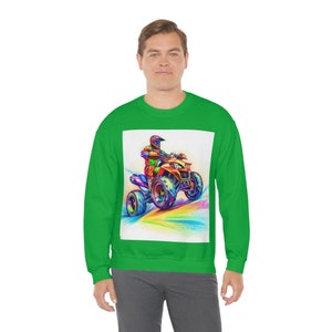 Puede incluir: Una sudadera verde con un gráfico colorido de una persona conduciendo un ATV sobre un fondo de arcoíris.