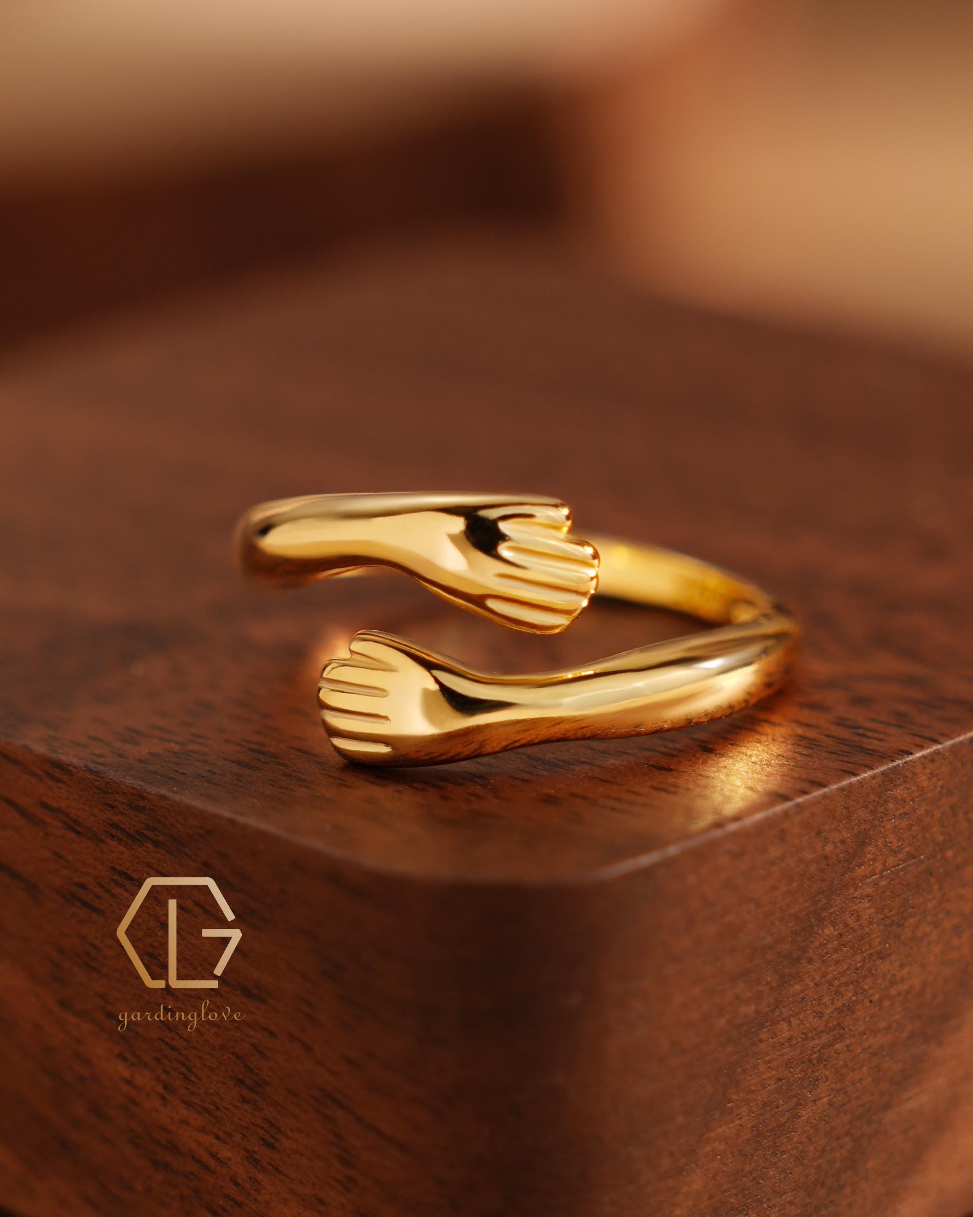 gold ring hugging arms ring