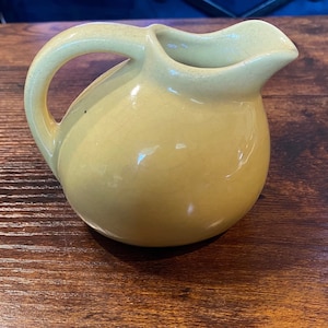 Jarra de cerámica con forma de bola inclinada, de mediados de siglo, color amarillo