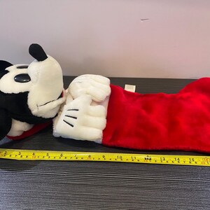 May include: A plush Mickey Mouse Christmas stocking. The stocking is red with a white cuff and Mickey's white gloved hand. Mickey's head is black and white. The stocking measures approximately 18 inches long.