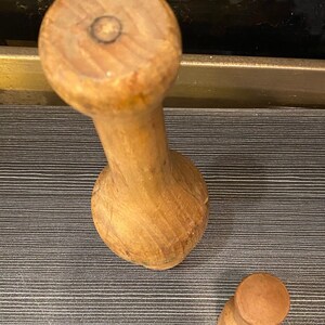 Peut inclure: Un ensemble de mortier et pilon en bois. Le mortier est de couleur brun clair avec une base arrondie et une longue poign&eacute;e cylindrique. Le pilon est une pi&egrave;ce cylindrique plus petite avec un dessus arrondi. L'ensemble est en bois.