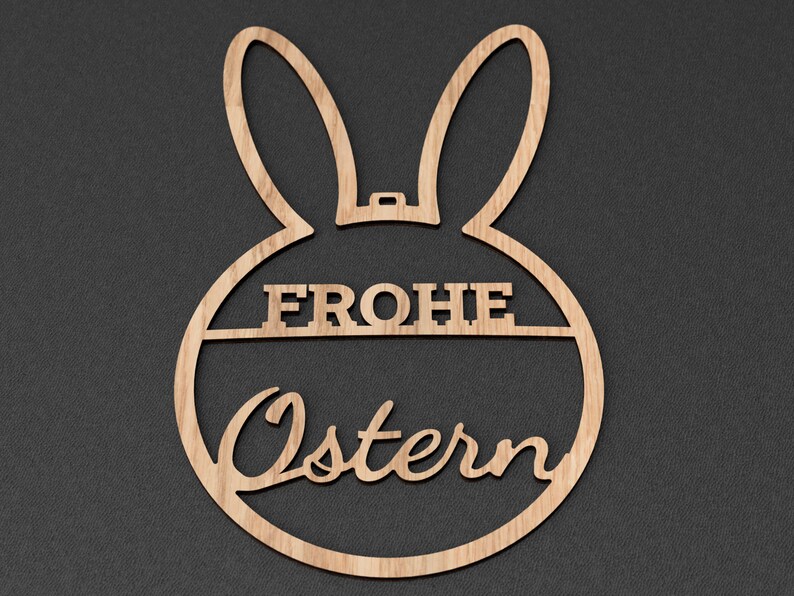 Może przedstawiać: Drewniany wycinany kr&oacute;lik wielkanocny z tekstem "Frohe Ostern" w języku niemieckim.