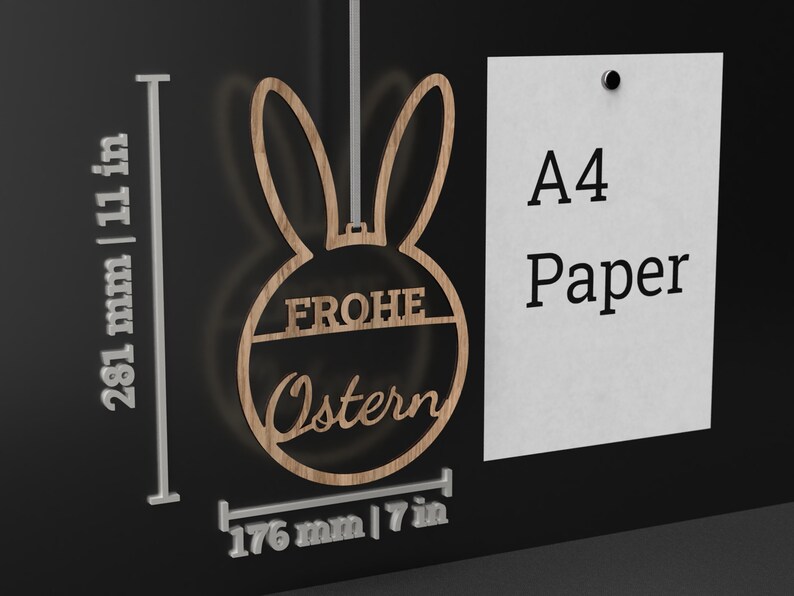 Może przedstawiać: Drewniana ozdoba wielkanocna w kształcie kr&oacute;lika z napisem "Frohe Ostern" w k&oacute;łku. Ozdoba ma 176 mm szerokości i 281 mm wysokości.