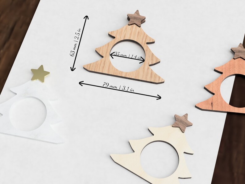 May include: Three wooden Christmas tree napkin rings with gold stars on top. The rings are 3.1 inches wide and 2.5 inches tall.