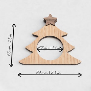 May include: Wooden Christmas tree napkin ring with a star on top. The ring measures 3.1 inches wide and 2.5 inches tall. The opening for the napkin is 1.4 inches wide.