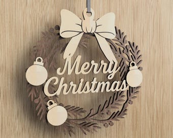 May include: Wooden Christmas wreath with a bow and three ornaments. The words "Merry Christmas" are cut out in the center of the wreath. The wreath is made of light and dark brown wood and hangs from a gray ribbon.