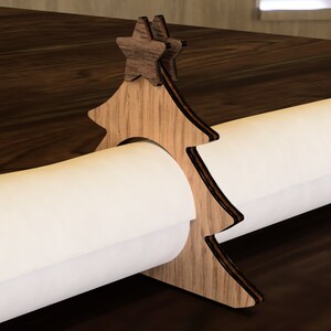 May include: Wooden Christmas tree-shaped paper towel holder with a star on top. The holder is holding a roll of white paper towels.