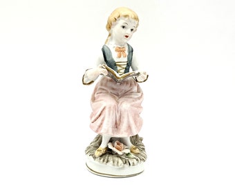 Vintage Ceramic Woman Figurine - Young Lady with Blonde Hair Sitting on Tree Trunk Reading Book - Pink, Blue, Green, & Yellow Pastel Colors