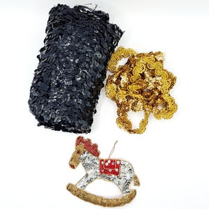 May include: A black sequined fabric, a gold trim, and a rocking horse ornament made of sequins. The rocking horse is silver with red and gold accents.