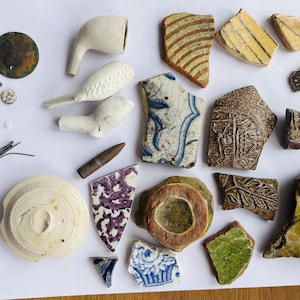 Paquete de búsqueda de lodo n.° 32: Historia del Reino Unido: pipas de arcilla, cerámica romana, Bellarmine, alfileres, granates, botones