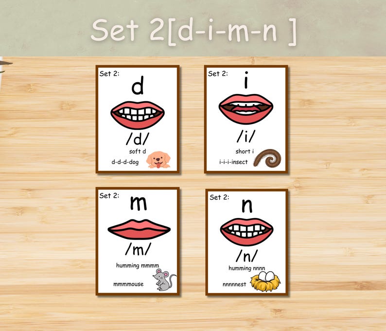 May include: Educational flashcards for phonics, featuring the letters d, i, m, and n. Each card displays a mouth shape, phonetic symbol, and a corresponding image. The set includes a dog, insect, mouse, and nest illustrations. The text "Set 2 [d-i-m-n]" is at the top.