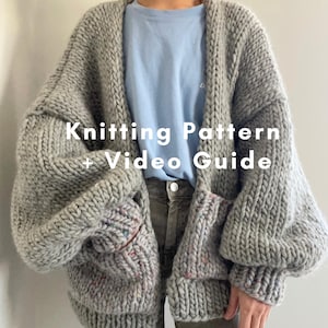 May include: A chunky grey knit cardigan with long sleeves and two front pockets, worn over a light blue t-shirt and dark pants. The text Knitting Pattern + Video Guide is overlaid in white across the center of the grey wool garment.