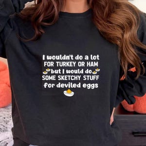 May include: Black long-sleeve sweatshirt with the text "I wouldn't do a lot FOR TURKEY OR HAM but I would do SOME SKETCHY STUFF for deviled eggs." The graphic includes a deviled egg illustration.
