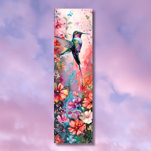 May include: A vibrant hummingbird with iridescent green and purple feathers hovers over a cluster of pink, red, and white flowers. The background is a soft pink watercolor wash.
