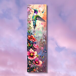 May include: A vibrant watercolor painting of a hummingbird in flight, surrounded by colorful flowers and splashes of paint. The hummingbird is green, blue, and purple with a long, thin beak. The flowers are pink, red, and yellow. The background is a soft, pastel pink.