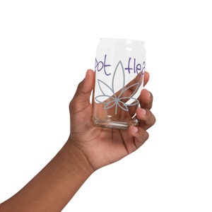 May include: A clear glass cup with a gray marijuana leaf design and the words "Pot Head" written in purple.