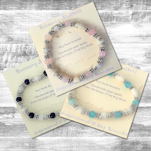 May include: Three bracelets made from paper beads from the pages of the Big Book. The bracelets are on cards with the text "Recovery Matters", "Inspirational 12 Step Reminders", and "Big Book Bracelet".