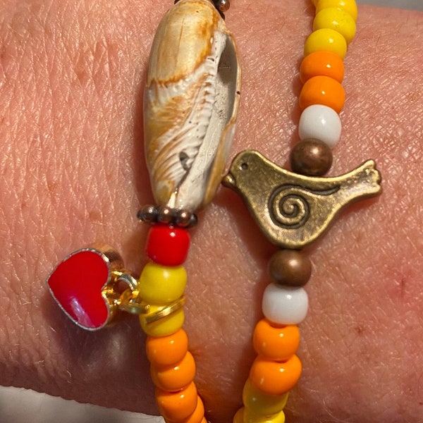 Handmade orange/red/yellow beaded bracelet with metal bird and Tybee Island Olive shell and small red heart charm