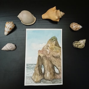 Peut inclure: Peinture à l'aquarelle d'une falaise rocheuse avec une ouverture de grotte, sur fond de ciel bleu et d'océan. La peinture est encadrée et entourée de coquillages.