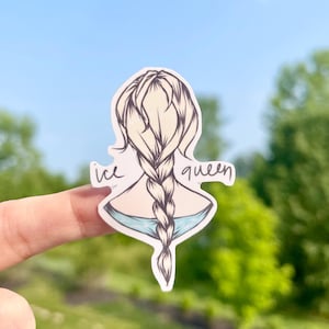 May include: A sticker featuring a cartoon illustration of a woman's back with a blonde braid. The words "ice queen" are written in cursive. The sticker has a light blue and white color scheme, with a hint of blue in the background.