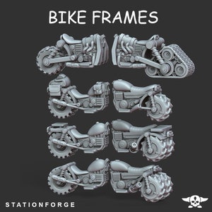 May include: A set of six 3D printed motorcycle frames, each with a different design. The frames are all in a gray color and are shown from different angles. The frames are labeled "BIKE FRAMES" and "STATIONFORGE".