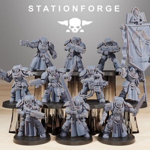 May include: A group of ten gray plastic miniature figures of space warriors, some holding weapons, standing on a tiered platform. The figures are arranged in a circle around a banner with the text "STATIONFORGE".
