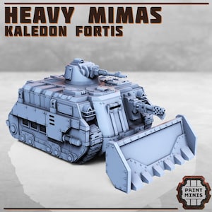 May include: A gray 3D printed model of a heavy Mimas tank with a large blade on the front. The tank has a turret with a cannon and a smaller machine gun. The text "HEAVY MIMAS KALEODON FORTIS" is printed on the top of the model.
