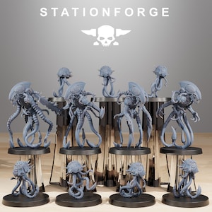 May include: A set of nine gray, detailed, plastic miniature figures of alien creatures with tentacles and multiple legs. The figures are arranged on circular bases and displayed on a table with a white background. The text "STATIONFORGE" is displayed at the top of the image.