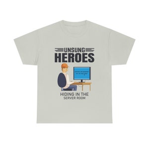 Può includere: T-shirt grigio chiaro con la scritta "UNSUNG HEROES" sopra un'illustrazione di una persona al computer. Lo schermo mostra "DESTROY THE INTERNET? YES | NO | NOT TODAY." Sotto l'illustrazione c'è la scritta "HIDING IN THE SERVER ROOM".