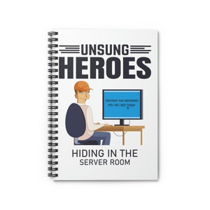 May include: A white spiral notebook with a cartoon illustration of a person sitting at a computer. The text on the notebook reads "Unsung Heroes" and "Destroy the Universe? Yes | No | Not Today". The text at the bottom of the notebook reads "Hiding in the Server Room".